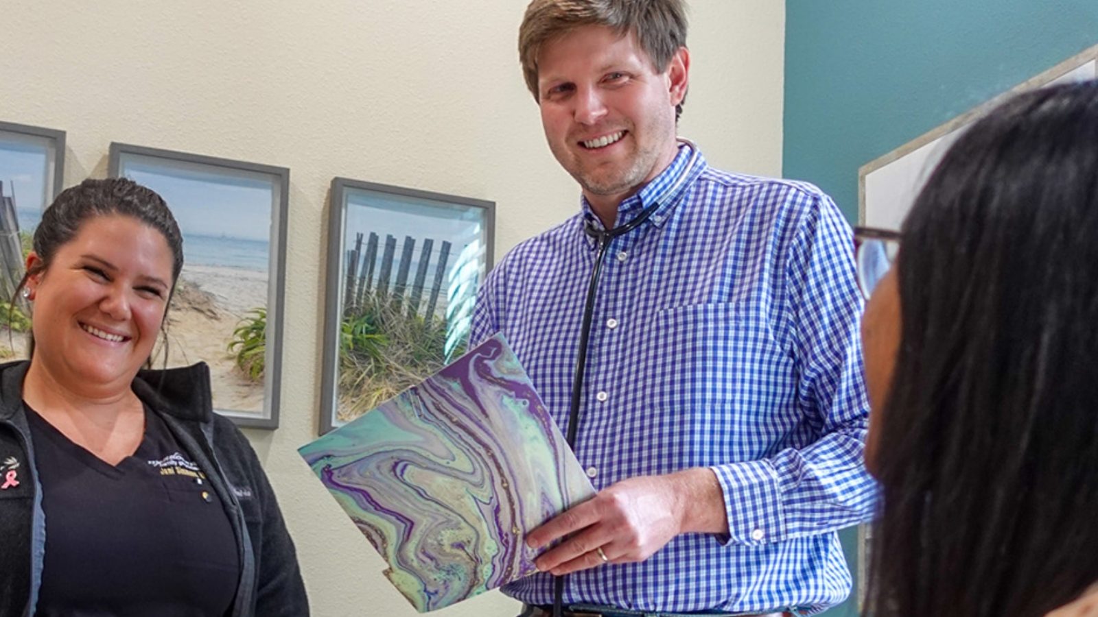Dr. Ryan Dickert reviewing care notes with a colleague and a patient