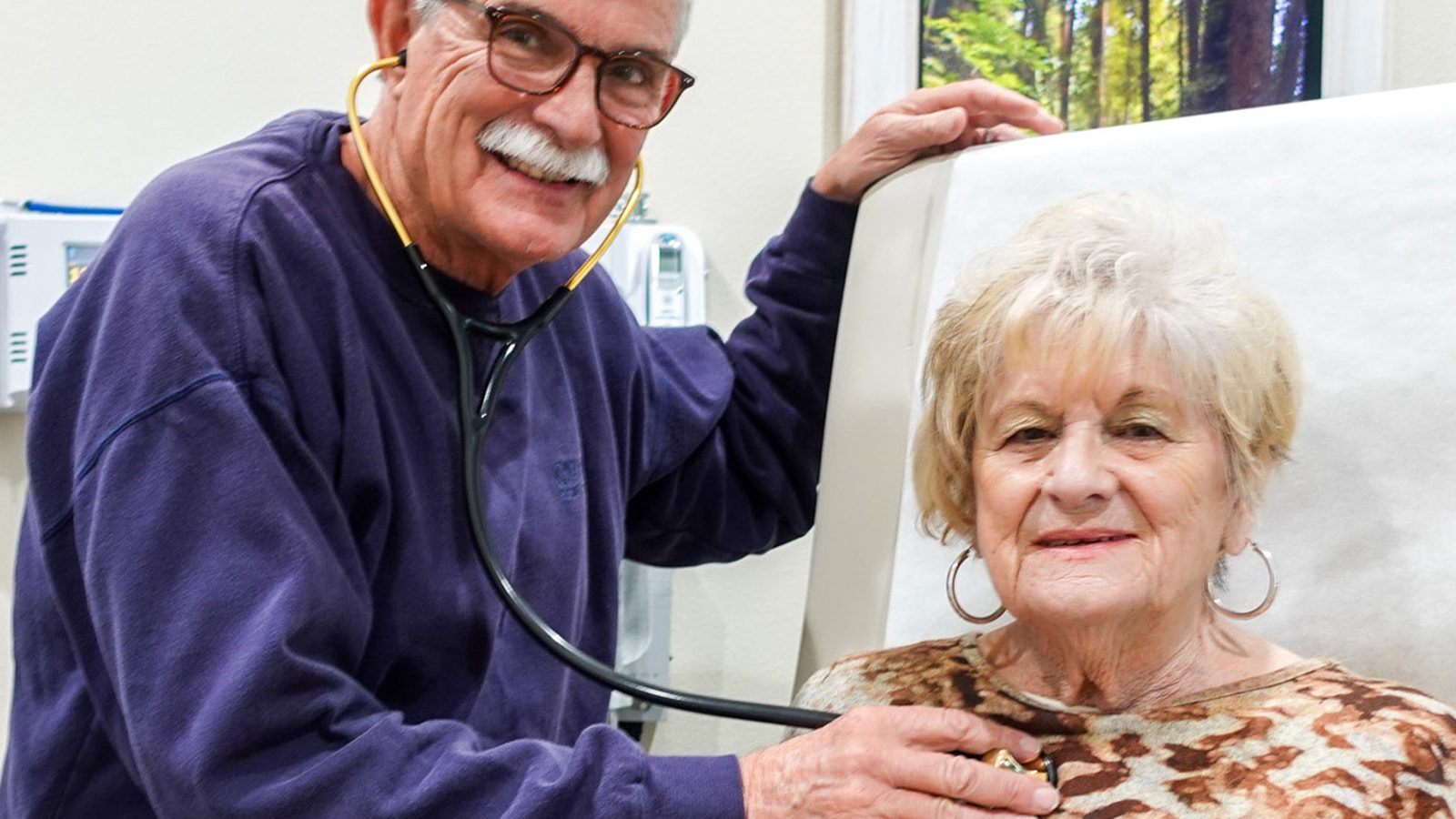 A Meadowcrest physician examining an elderly patient with a stethoscope